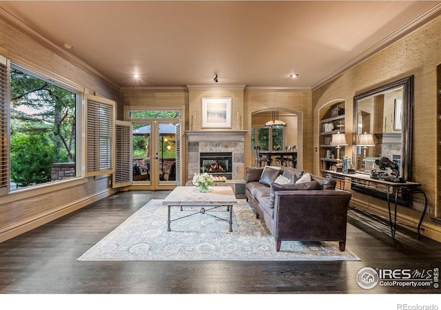 living room featuring built in shelves, crown molding, dark hardwood / wood-style flooring, and french doors