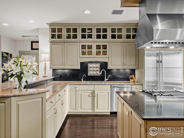 kitchen featuring cream cabinetry, appliances with stainless steel finishes, extractor fan, and light stone countertops