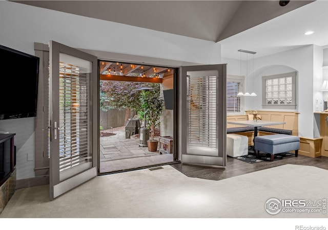 doorway to outside featuring lofted ceiling