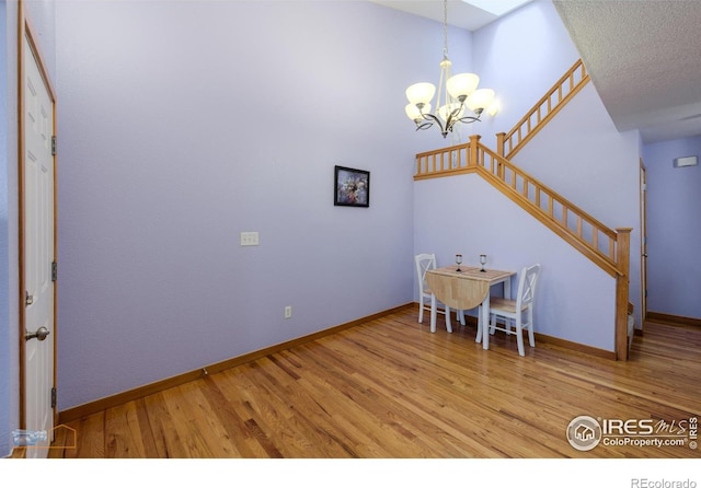 dining space with a notable chandelier and light hardwood / wood-style floors