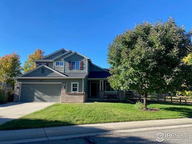 craftsman-style home with brick siding, an attached garage, fence, a front yard, and driveway