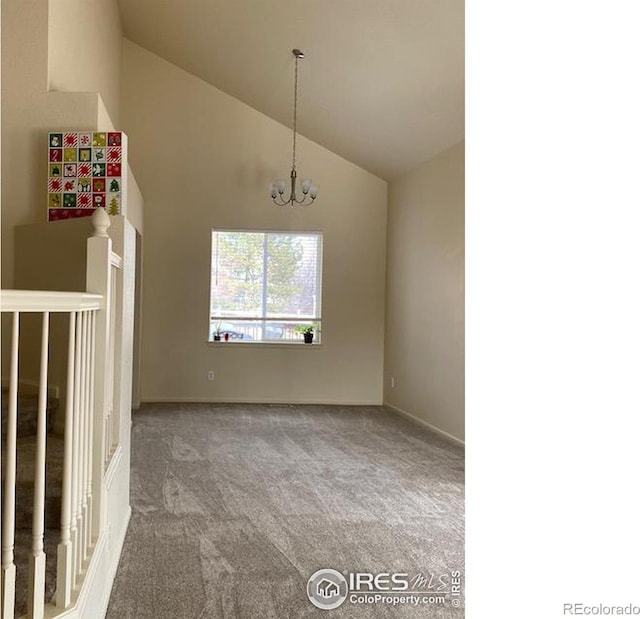 spare room featuring carpet floors, high vaulted ceiling, and an inviting chandelier