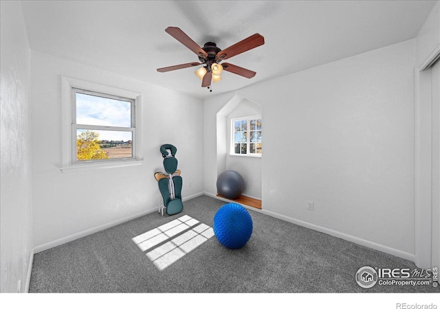 workout area with dark colored carpet and ceiling fan