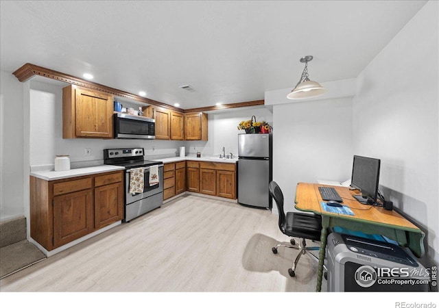 kitchen with decorative light fixtures, light hardwood / wood-style floors, sink, and appliances with stainless steel finishes