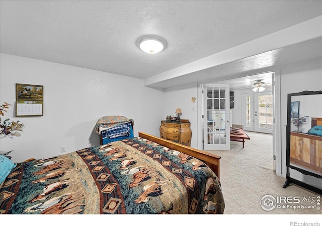 carpeted bedroom with a textured ceiling and french doors