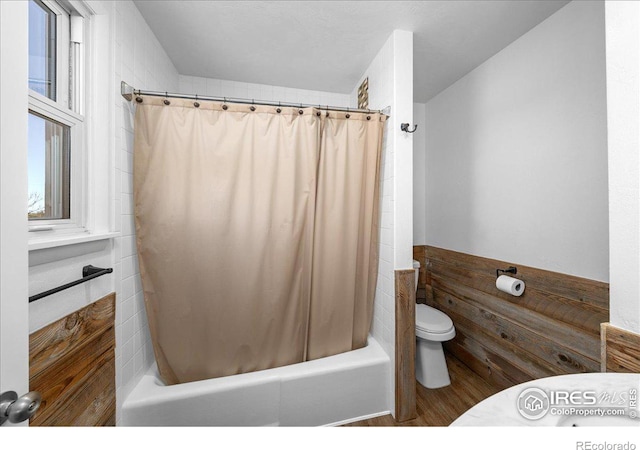 bathroom featuring shower / tub combo and toilet