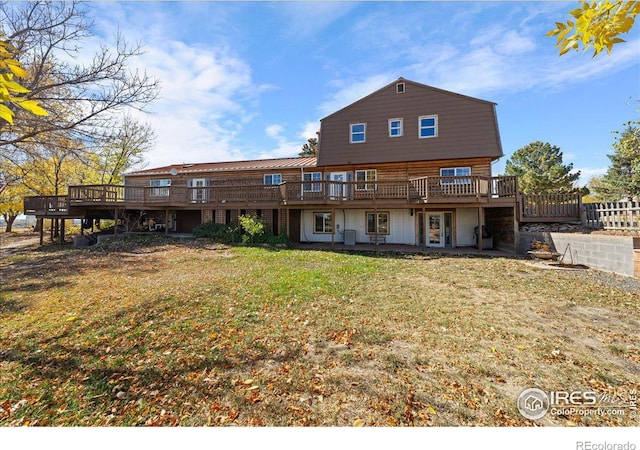 back of property featuring a lawn and a deck