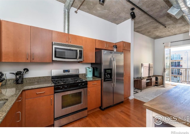 kitchen featuring appliances with stainless steel finishes and light hardwood / wood-style flooring