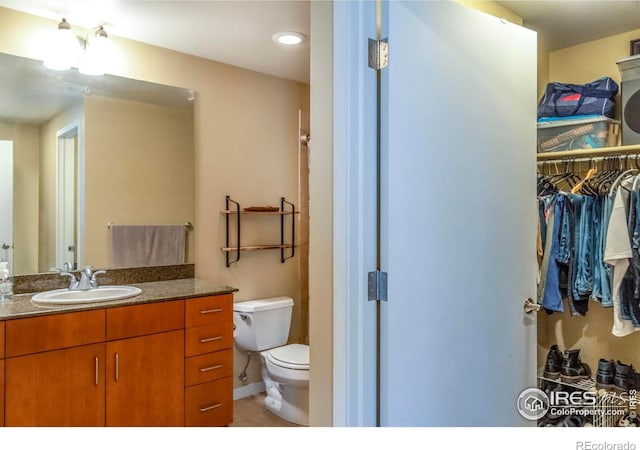 bathroom featuring vanity, tile patterned flooring, and toilet