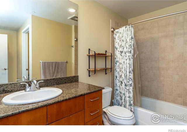 full bathroom with vanity, shower / tub combo with curtain, and toilet