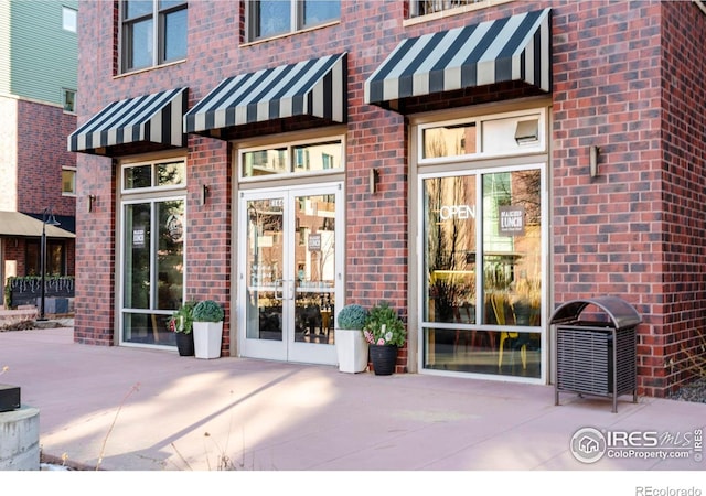 property entrance featuring a patio and french doors