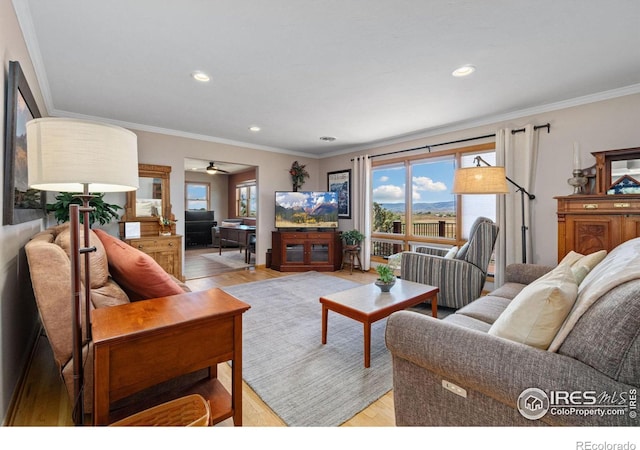 living room with ornamental molding, a wealth of natural light, and light hardwood / wood-style flooring