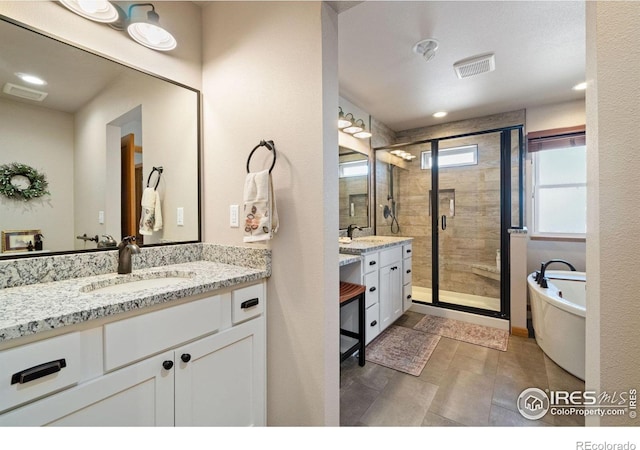 bathroom with vanity and shower with separate bathtub