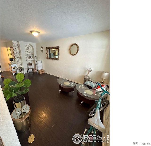 living room featuring a textured ceiling and hardwood / wood-style flooring