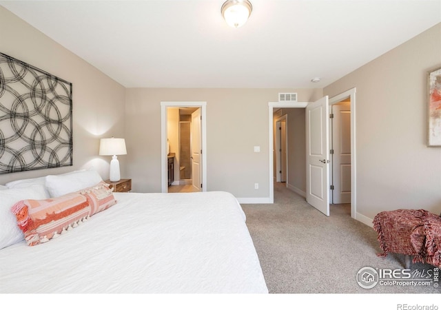 bedroom featuring carpet, visible vents, ensuite bath, and baseboards