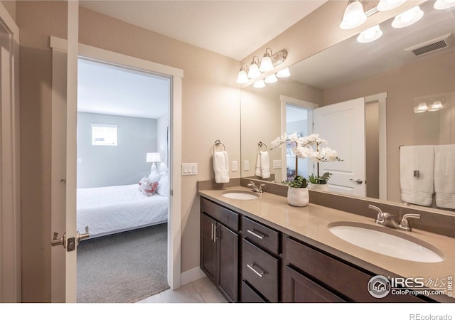 full bathroom with double vanity, visible vents, a sink, and ensuite bathroom