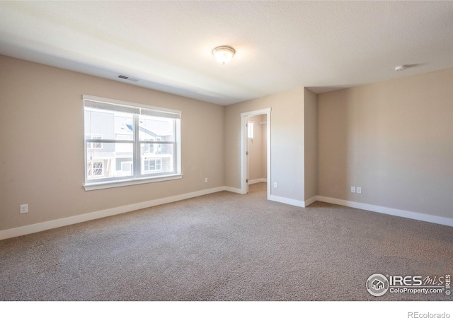 spare room featuring light carpet, baseboards, and visible vents