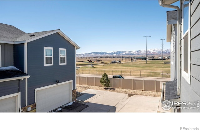 view of patio / terrace featuring a garage, a mountain view, and fence