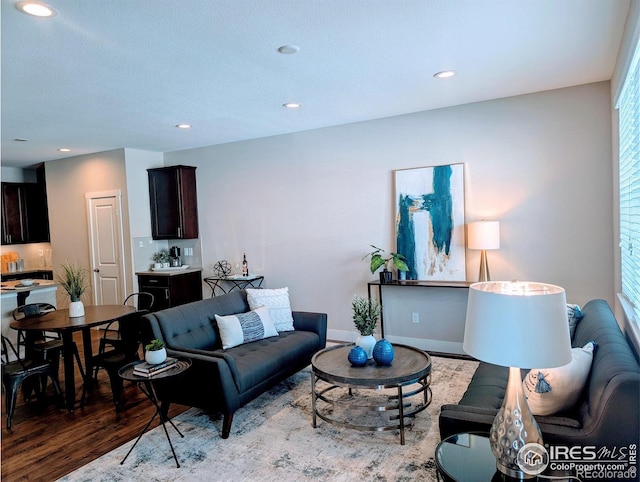 living room with baseboards, light wood-type flooring, and recessed lighting