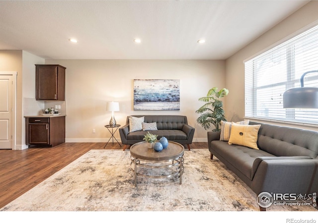 living area with dark wood-type flooring, recessed lighting, and baseboards