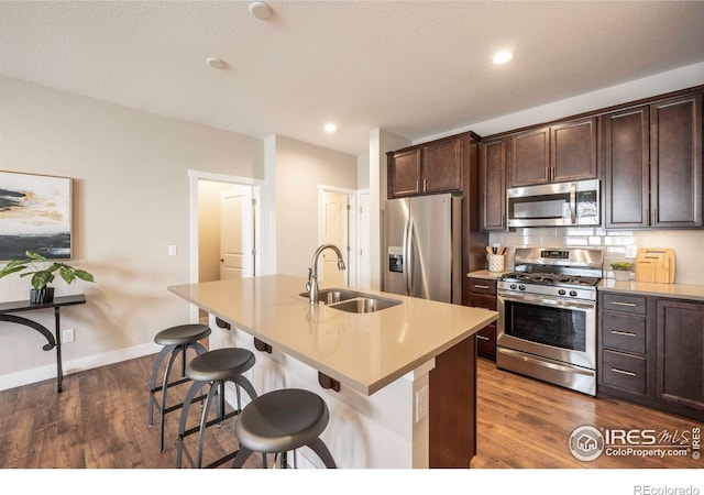 kitchen with a center island with sink, a breakfast bar area, stainless steel appliances, and a sink