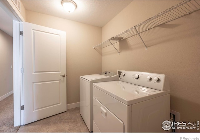 washroom featuring laundry area, washing machine and dryer, and baseboards