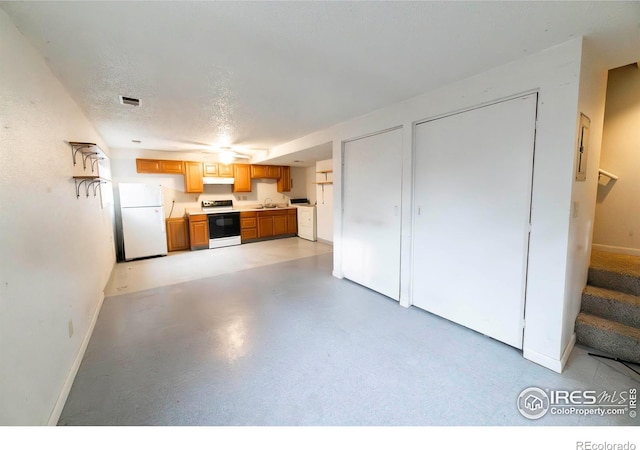 kitchen featuring a textured ceiling, sink, and white appliances