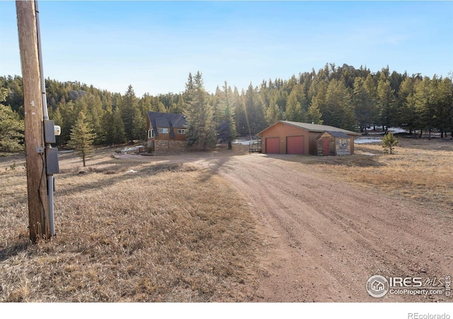 exterior space featuring a rural view, an outdoor structure, and a garage