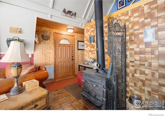 tiled entryway with a wood stove and wooden walls