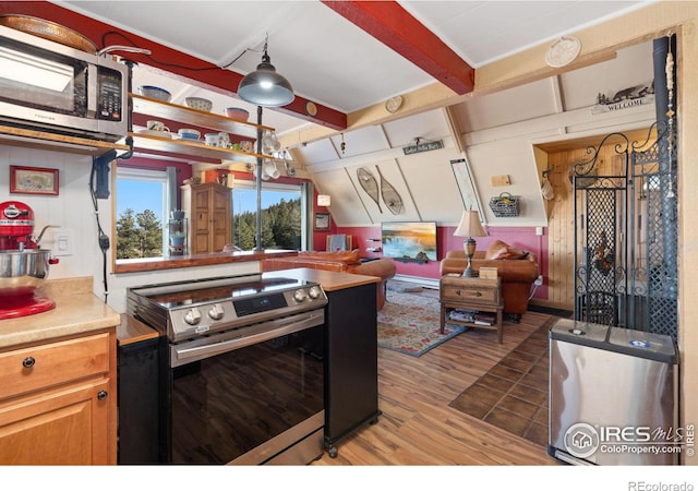 kitchen featuring hanging light fixtures, stainless steel appliances, lofted ceiling with beams, wood walls, and wood-type flooring