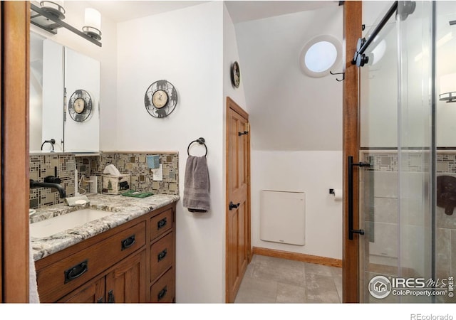 bathroom featuring decorative backsplash, an enclosed shower, and vanity