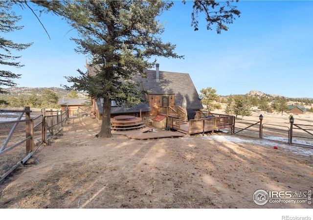 view of yard featuring a rural view and a deck with mountain view