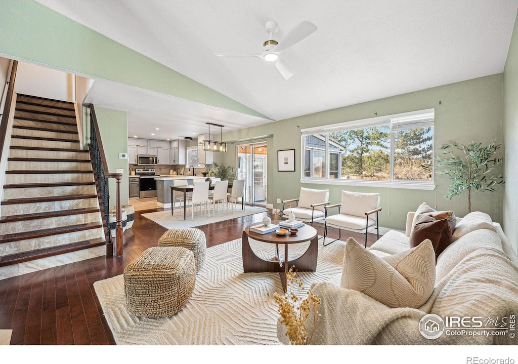 living room with hardwood / wood-style floors, ceiling fan, and lofted ceiling