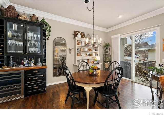 dining area featuring bar area, crown molding, beverage cooler, and a notable chandelier