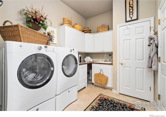 laundry area featuring cabinets, sink, and washing machine and dryer