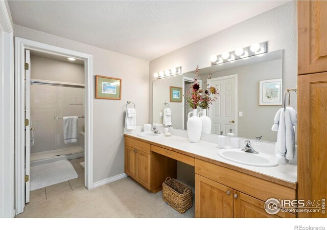 bathroom featuring tile patterned floors, vanity, and a shower with shower door