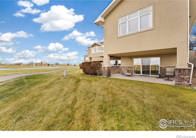 back of house featuring a patio and a lawn