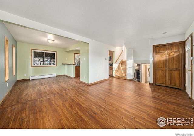 unfurnished living room with baseboard heating and hardwood / wood-style floors