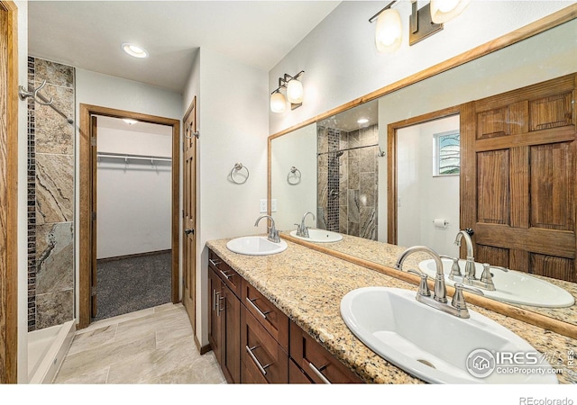 bathroom with vanity and tiled shower