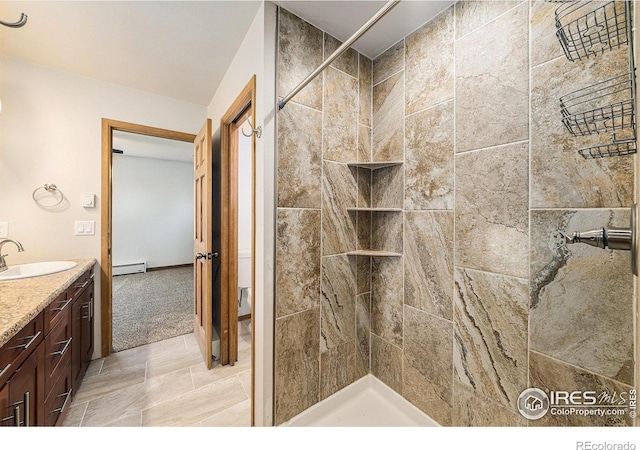 bathroom featuring vanity, tiled shower, and a baseboard radiator