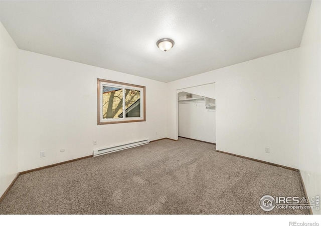 unfurnished bedroom with carpet flooring, a closet, and a baseboard heating unit