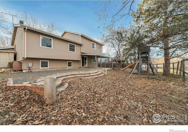 rear view of property featuring a playground