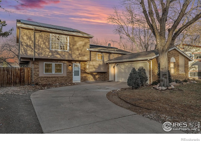 view of front of property featuring solar panels and a garage