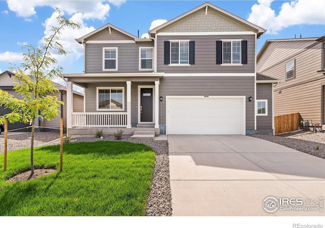 view of front of property with a porch, a garage, and a front yard