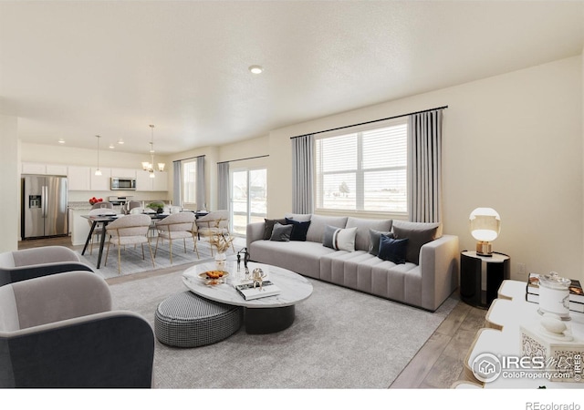 living room with a notable chandelier and light hardwood / wood-style floors