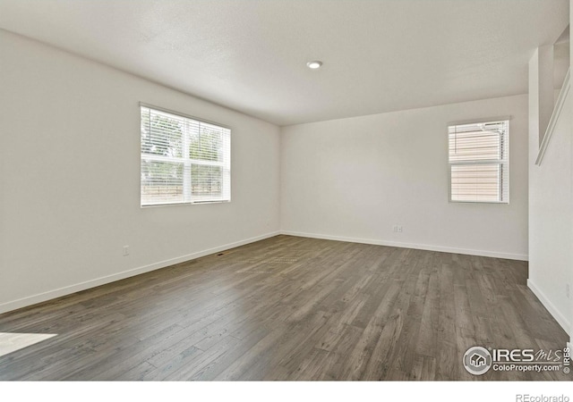 spare room with dark hardwood / wood-style flooring