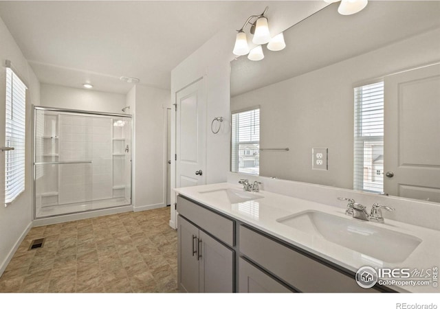 bathroom with plenty of natural light, vanity, and a shower with door