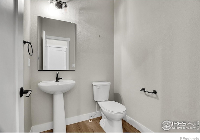 bathroom with wood-type flooring and toilet