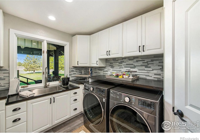 laundry room featuring washer and dryer, dark hardwood / wood-style floors, cabinets, and sink