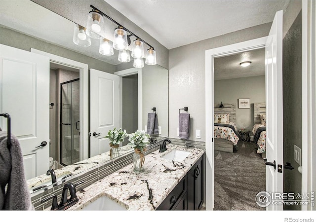 bathroom with vanity, a shower with shower door, a textured ceiling, and toilet